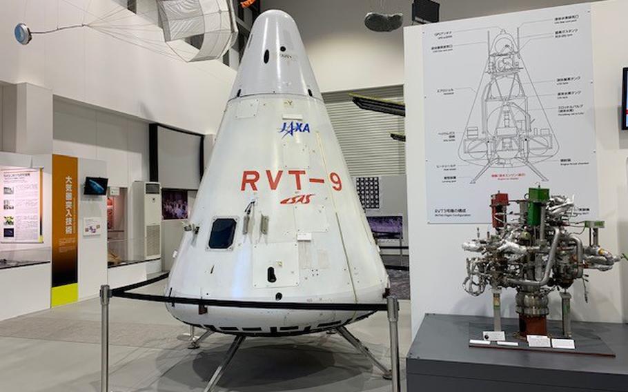 An exhibit at JAXA’s campus in Sagamihara, Japan, has full-sized models of various rockets and spacecraft, such as a reusable rocket, the RVT-9, and a model of the asteroid 162173 Ryugu, along with descriptions in both Japanese and English. 