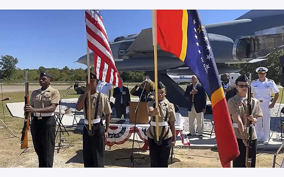 A video screen grab shows members of a JROTC honor guard presenting colors during a ceremony to dedicate a static display of an RF-4C Phantom II at a veterans park in Meridian, Mississippi.