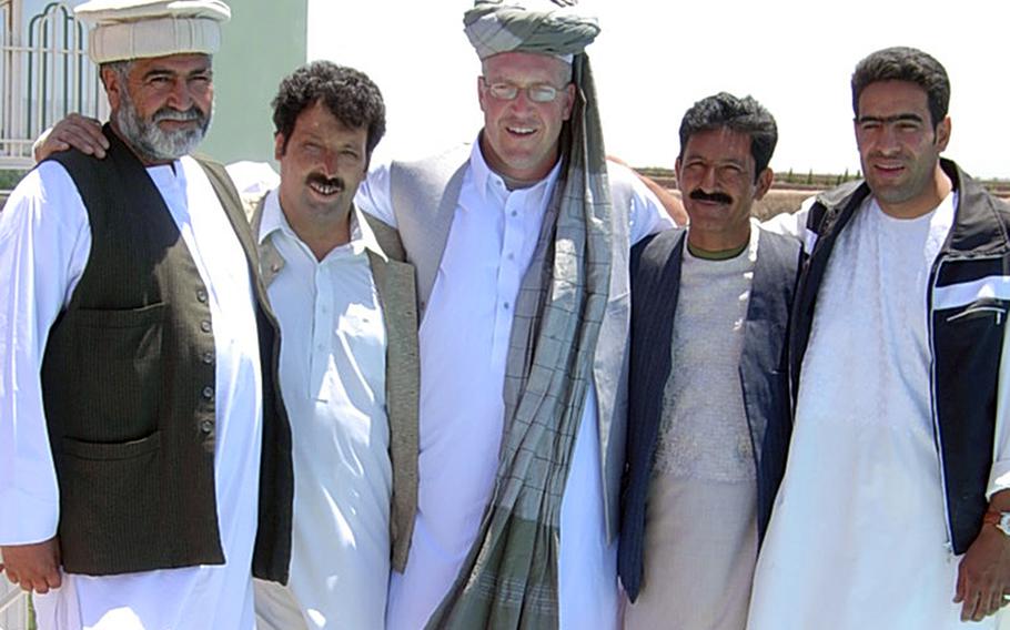 Sean Gustafson, center, dons local attire as he meets Afghan partners in Herat, Afghanistan, during his deployment from 2006-2007. Gustafson, a U.S. Army major at the time, believed then the war in Afghanistan was on track to being won.           