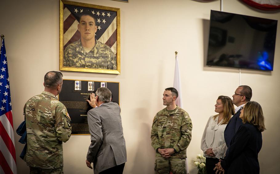 Robert Ollis, father of U.S. Army Staff Sgt. Michael Ollis, touches the embossed lettering of his son’s name on a memorial plaque at a ceremony Oct. 27, 2023. The dining facility at Camp Kosciuszko in Poznan, Poland, was named after Michael Ollis at the ceremony.