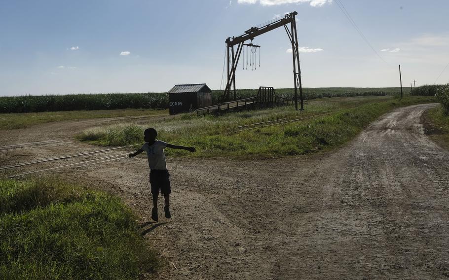 A youth plays near the machine where the sugar cane is weighed in the Lima batey, or neighborhood, in La Romana, where Central Romana Corporation, Ltd. operates its sugar operations in Dominican Republic, Nov. 17, 2021. The U.S. government announced Nov. 23, 2022 that it will detain all imports of sugar and related products made in the Dominican Republic by Central Romana Corporation, Ltd. amid allegations that it uses forced labor.