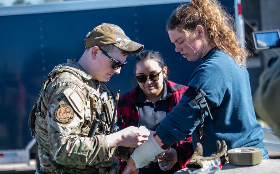 An airman bandages an injured role-play victim during a PATRIOT 24 search and rescue exercise, Camp Shelby, Miss., Monday, Feb. 19, 2024.