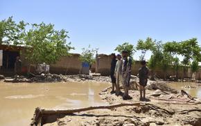 People stand near damaged homes after heavy flooding in Baghlan province, in northern Afghanistan, Sunday, May 12, 2024. Victims of the devastating floods in northern Afghanistan are burying the dead and looking for the loved ones still missing. (AP Photo)