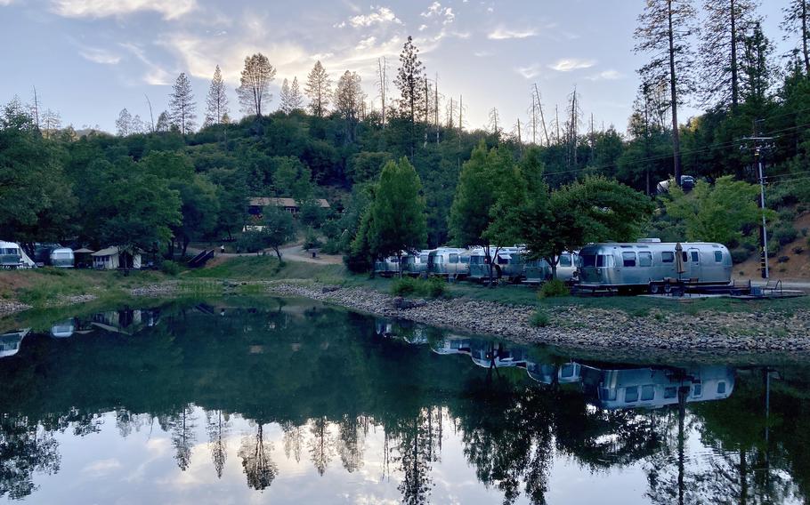 An evening in AutoCamp Yosemite with Airstream trailers settled around the central pond in Midpines, Calif. 