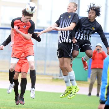 Nile C. Kinnick's Kou Nishiyama heads the ball against Matthew C. Perry's Joshua Norris and Dominic Williams during Saturday's DODEA Japan soccer match. The Red Devils won 5-0.