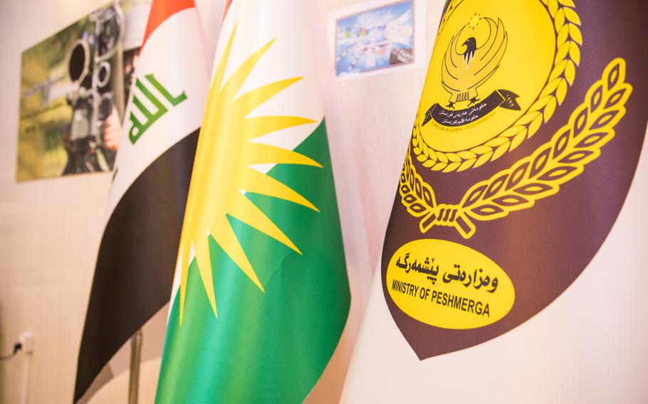 The Iraq, Kurdistan, and Ministry of Peshmerga flags are displayed during a meeting between a Coalition Forces psychological operations team and  members of the Peshmerga media cell at the Ministry of Peshmerga in Erbil, Iraq, May 2, 2019. 