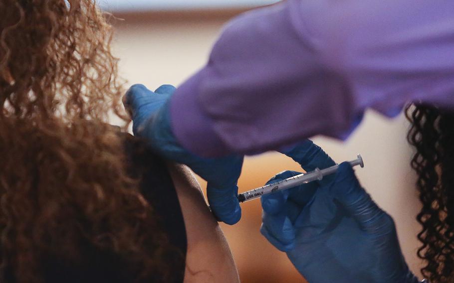 A nurse receives a booster dose of the COVID-19 vaccine during a vaccination drive in Norfolk, Va. on Dec. 28, 2021.