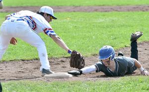 Wiesbaden's Jonah Harvey dives back to first base ahead of the tag by Ramstein's Conor McGinty during the second game of a doubleheader on April 6, 2024, on Clay Kaserne in Wiesbaden, Germany.