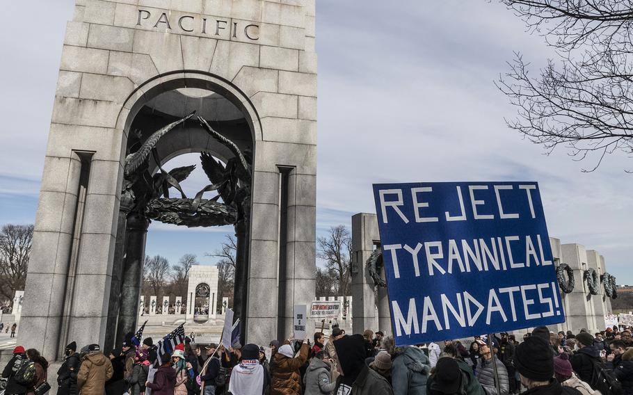 Participants in a rally in opposition to vaccine mandates march past the National World War II Memorial on their way to the Lincoln Memorial in Washington, D.C., Jan. 23, 2022.