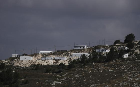 A few white buildings on a hill.