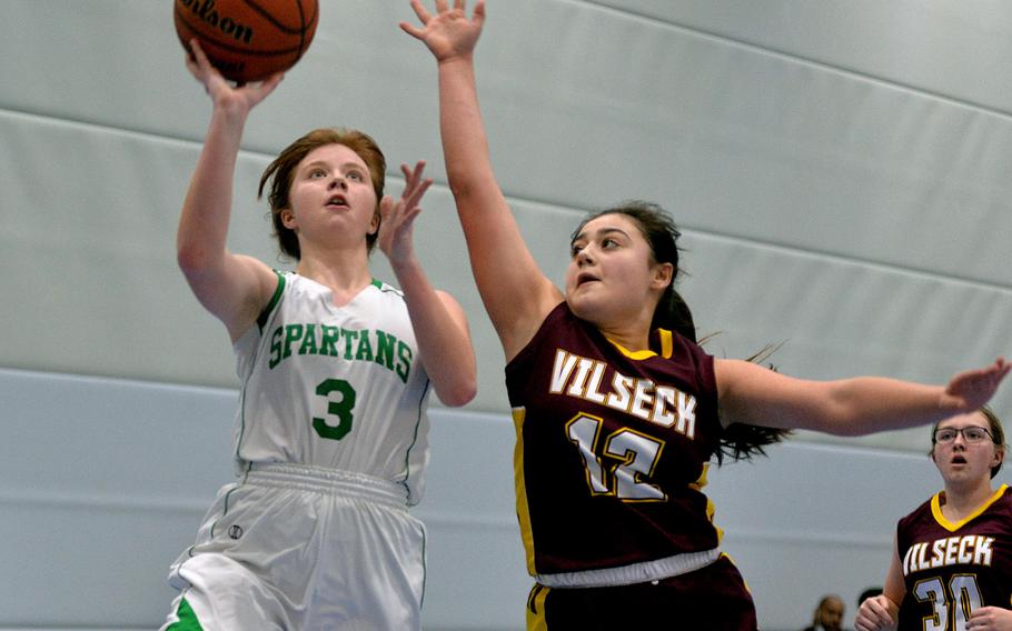 SHAPE’s Macy Gilbert shoots as Vilseck’s Addison Shepherd tries to block in a game on opening day of the DODEA-Europe Division I championships in Ramstein, Germany, Feb. 23, 2022. Vilseck won 36-35.