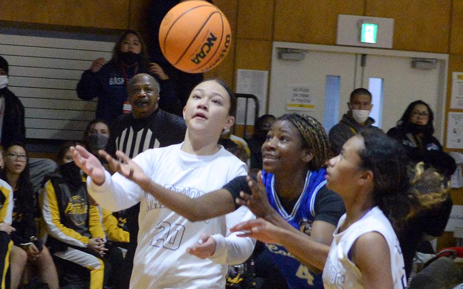 Osan's Tatiana Lunn chases down the ball between two St. Paul Christian defenders during Thursday's pool game in the 5th American School In Japan Kanto Classic basketeball tournament. The Warriors won 54-5.
