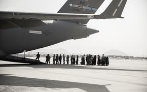 Evacuees wait to board a Boeing C-17 Globemaster III during an evacuation at Hamid Karzai International Airport, Kabul, Afghanistan, Aug. 30. U.S. service members are assisting the Department of State with a Non-combatant Evacuation Operation (NEO) in Afghanistan. (U.S. Marine Corps photo by Staff Sgt. Victor Mancillal)