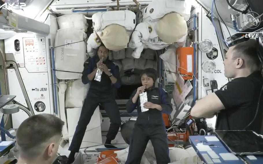 In this image from NASA TV, Ali al-Qarni, second from left, and Rayyanah Barnawi of Saudi Arabia, second right, have a drink alongside two cosmonauts in the International Space Station, Monday, May 22, 2023. The space station rolled out the welcome mat for the two Saudi visitors, including the kingdom’s first female astronaut.