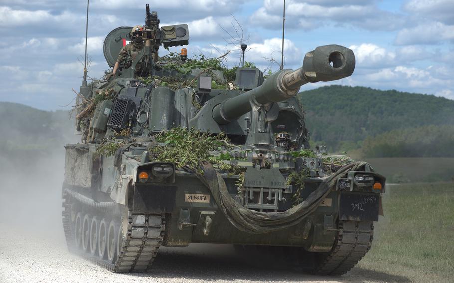 A soldier rides atop the mobile artillery system