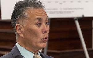 A close-up view of a congressman, seen from the neck up, speaking during a meeting.