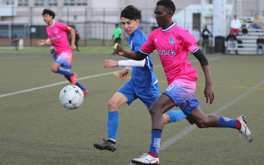 Nile C. Kinnick's Elias Alvord and Yokota's Kai Patton chase the ball during Thursday's DODEA-Japan/Kanto Plain boys soccer match. The Red Devils won 2-0.