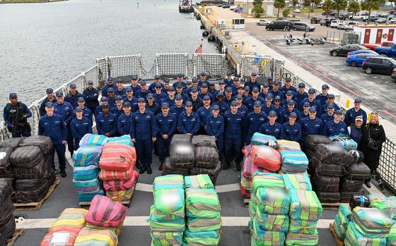 The crew of the Coast Guard Cutter Resolute pose in front of interdicted drugs, Jan. 29, 2024, St. Petersburg, FL. Drug interdiction is one of the 11 statutory missions of the Coast Guard. (U.S. Coast Guard photo by Petty Officer 3rd Class Nicholas Strasburg)