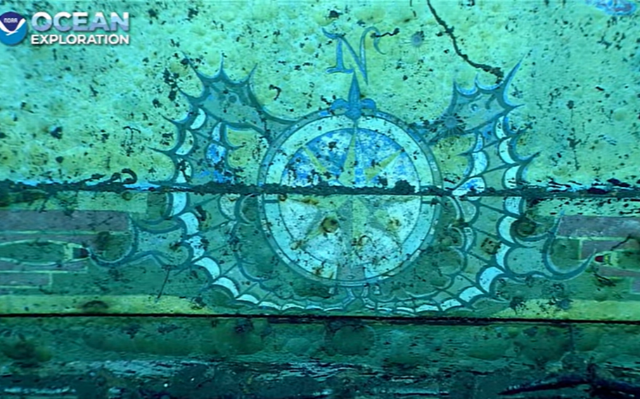 A pair of painted seahorses surround a compass rose on a mural of a sunken ship.
