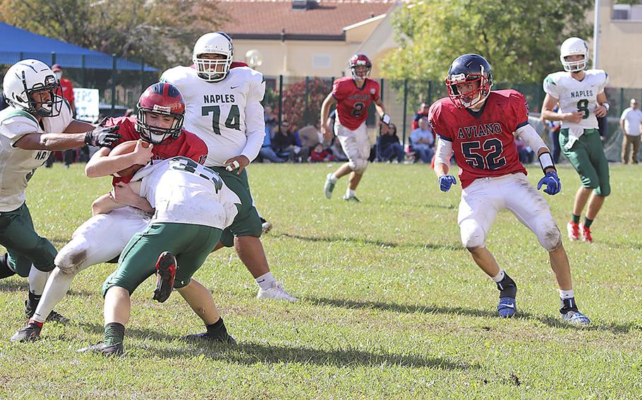 Aviano’s Julian Riley gets tackled by Naples Wildcat defenders during Saturday’s football game held at Aviano. The Wildcats won the game decisively by the score of 40-0.