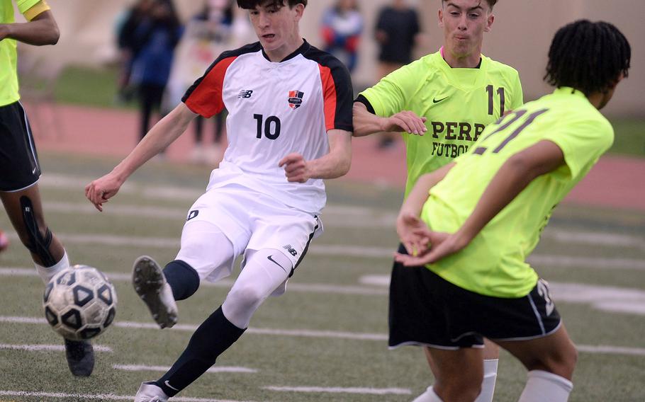 Nile C. Kinnick's Ryo Nishiyama launches a kick for one of his 10 goals, this one against James Williams and Matthew C. Perry, during Thursday's All-DODEA-Japan soccer tournament. The Red Devils routed the Samurai 12-0.