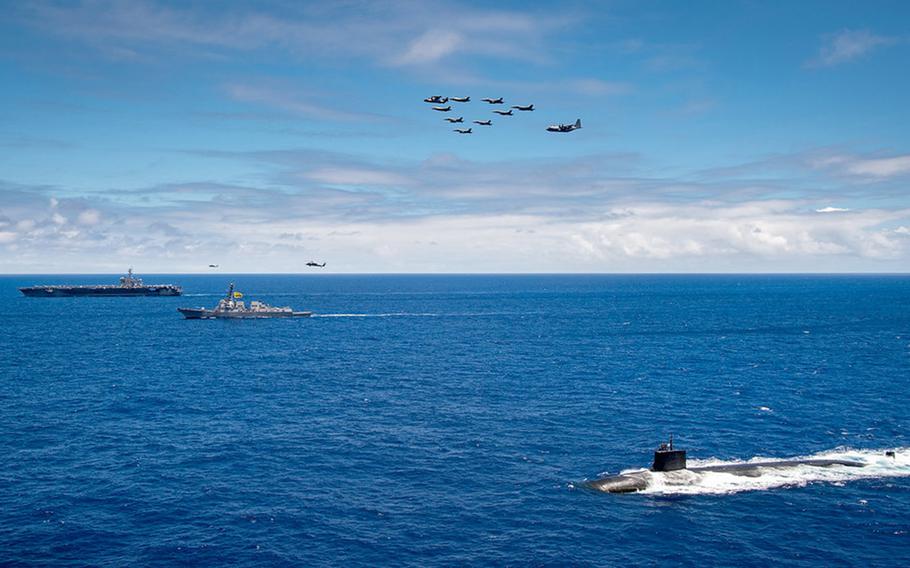 The aircraft carrier USS Carl Vinson, guided-missile destroyer USS Dewey and attack submarine USS Seawolf sail in formation near Hawaii while Marine Corps aircraft fly overhead, June 22, 2021. 