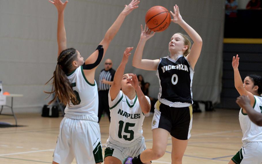 Vicenza’s Addison Kropp takes a shot over Naples’s JuJu Martinez, left, and Kennedy Rascoe in a Division II semifinal at the DODEA-Europe basketball championships in Ramstein, Germany, Feb. 17, 2023. The Wildcats beat the Cougars 49-39.