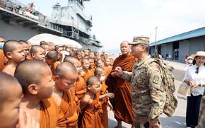 U.S. Army Chaplain (Capt.) Songkran Waiyaka, a former Buddhist monk from Thailand, speaks with novice monks during a Cobra Gold cultural exchange at the port in Sattahip, Thailand.