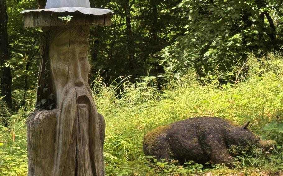 Wooden carvings of a druid and a pig.