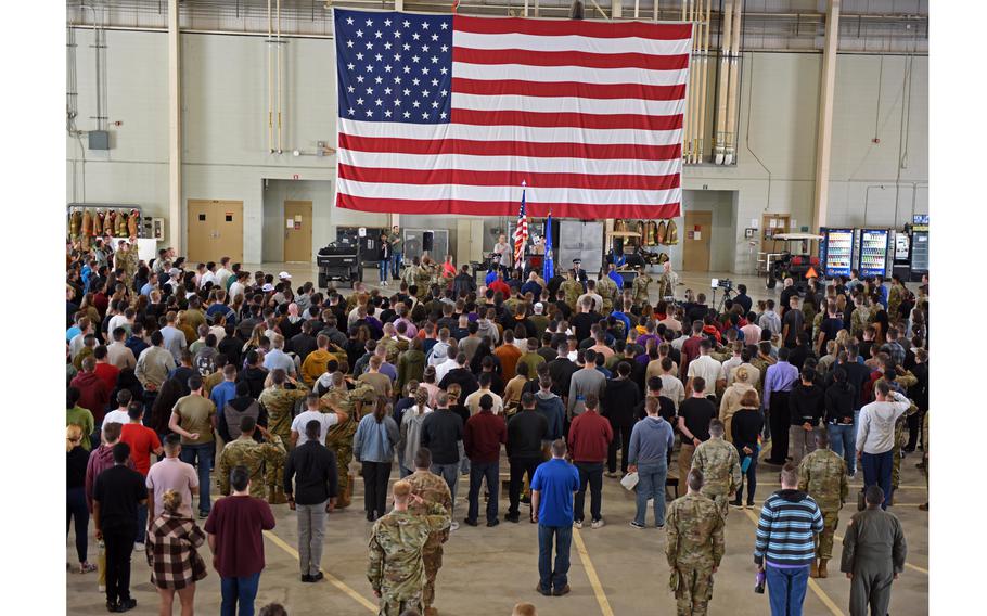 A crowd of people gather together under the flag of the United States of America