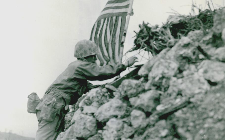 Marine Lt. Col. R.P. Ross Jr., of Frederick, Md., plants the American flag on one of the remaining ramparts of ancient Shuri castle on Okinawa. 