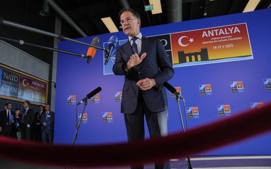 Mark Rutte seen from the legs up, speaking before microphones.