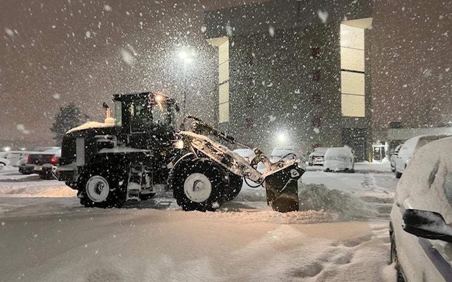 A New York Army National Guard soldier assigned to the 827th Engineer Company uses a front-end loader to clear snow from the parking lot at the Erie County Fire Training Academy in Cheektowaga, N.Y., on Dec,. 26, 2022. The New York National Guard mobilized 450 airmen and soldiers to respond to the storm.