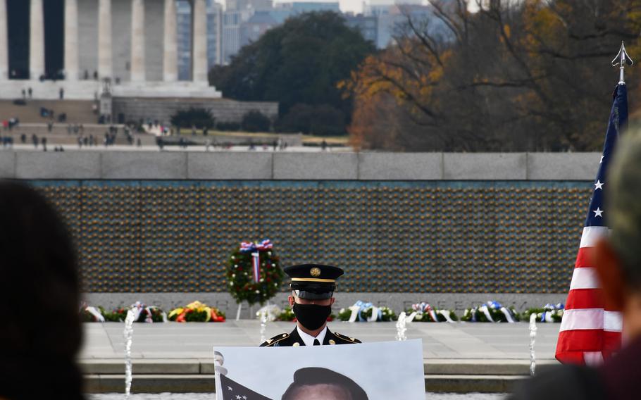 A service member stands guard over a portrait of Bob Dole at a public remembrance for the late senator on Friday, Dec. 10, 2021, at the National World War II Memorial.  