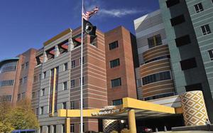 Brown, gray and white buildings are seen on a sunny day with the U.S. flag raised.