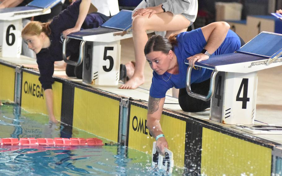 Sigonella parent Ashlee Fowler shows her swimmer how many laps there are left in an 800-meter freestyle race at the European Forces Swim League Long Distance Championships on Saturday, Nov. 26, 2022, in Lignano Sabbiadoro, Italy.
