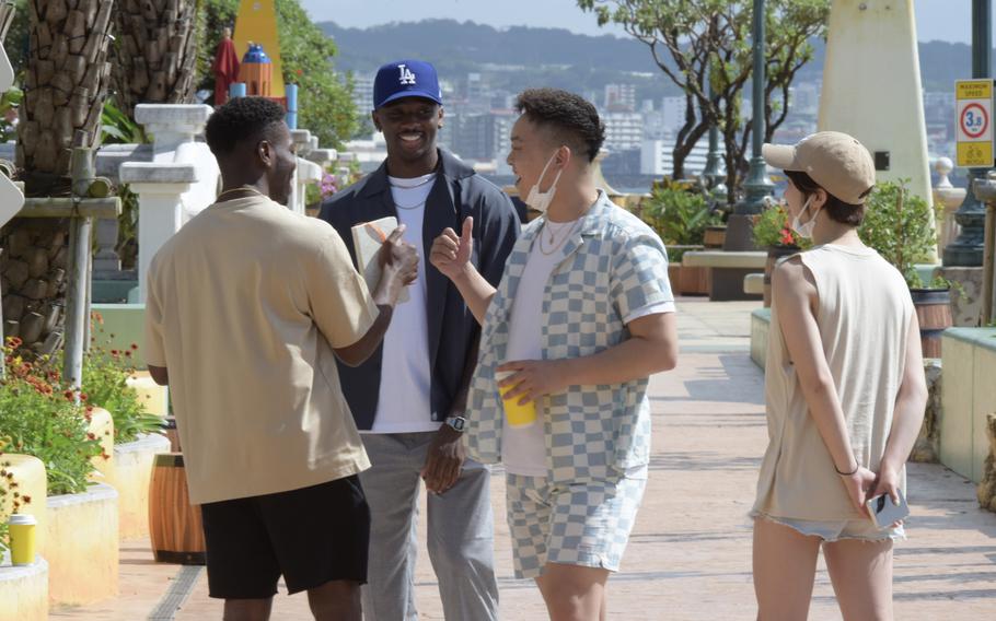 People hang out in American Village, an American-themed outdoor mall in Chatan, Okinawa, Thursday, May 12, 2022. 