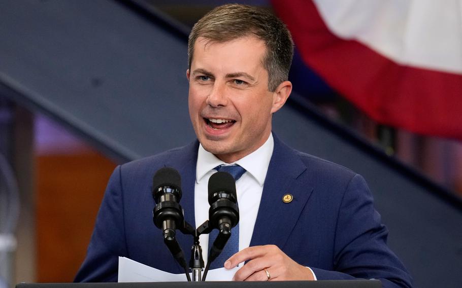 Pete Buttigieg speaking at a podium in front of two microphones.