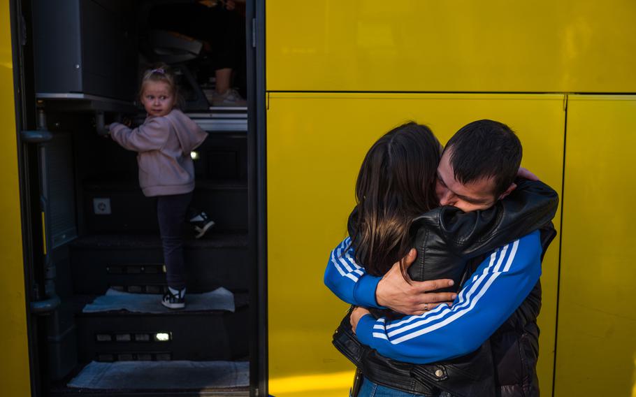 Sasha Valuiskyi hugs his wife goodbye outside the bus in Zaporizhzhia.