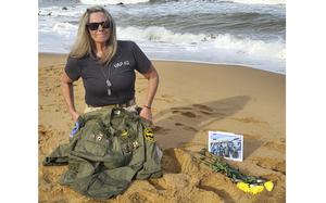This photo provided by Jeanie Jacobs Huffman shows her on the beach in June 2024, two miles away from where her father's plane and crew were discovered in 70 feet of water, in Thanh Hoa Province, Vietnam. (Dave Huffman/Jeanie Jacobs Huffman via AP)