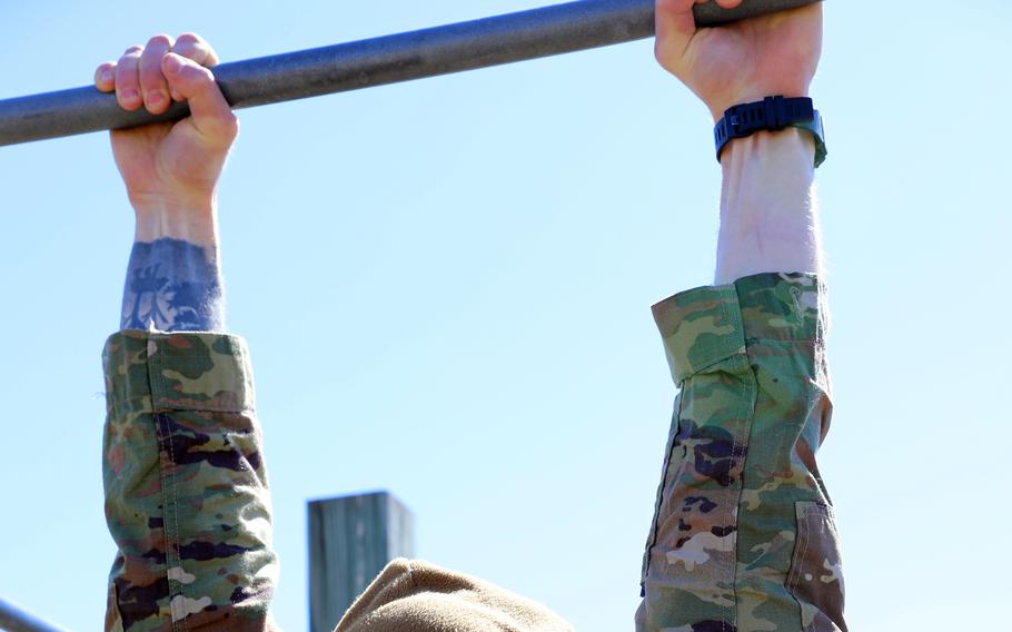 A U.S. Army soldier performs a dead hang during a Best Warrior competition at Fort McCoy, Wis., April 9, 2022.