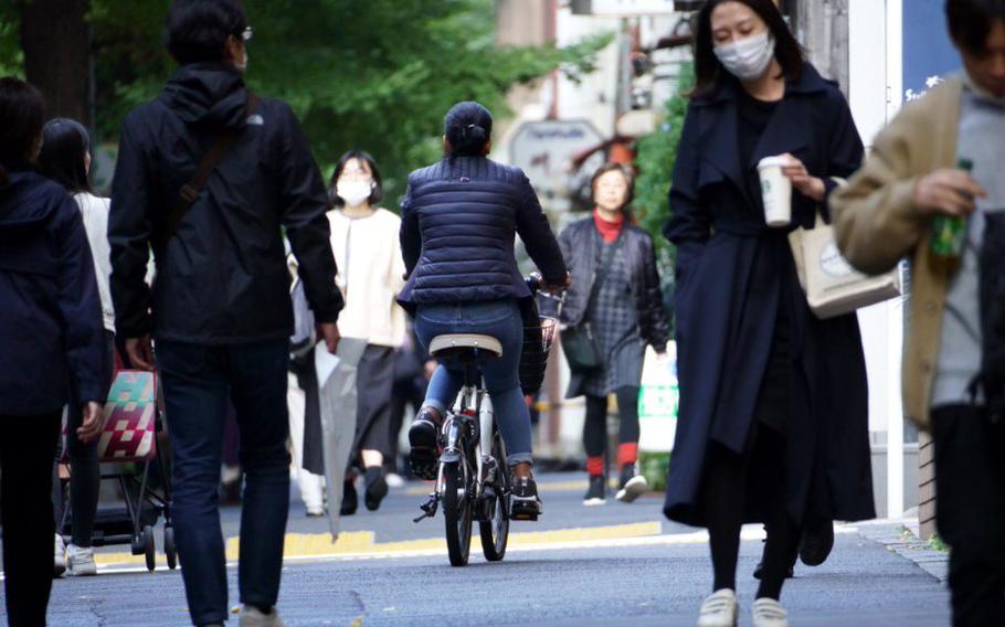 On November 10, 2022, a cyclist drives on a crowded sidewalk in Tokyo.