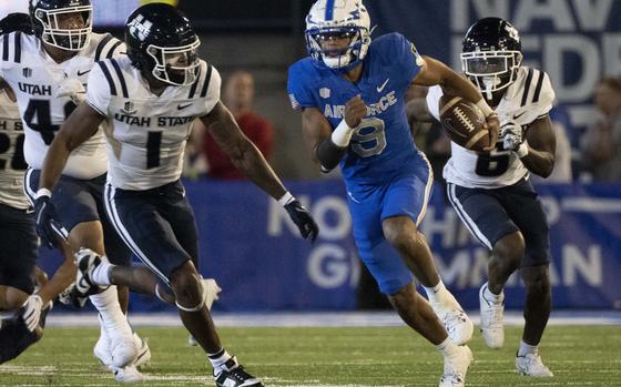 Air Force quarterback Zac Larrier (9) runs downfield for a first down against Utah State safeties Anthony Switzer (1) and Ike Larsen (6) during the first half of an NCAA college football game in Air Force Academy, Colo., Friday, Sept. 15, 2023. (Christian Murdock/The Gazette via AP)