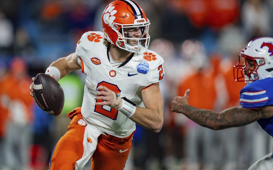 Klubnik, with the football in his right hand, tries to evade a tackler.