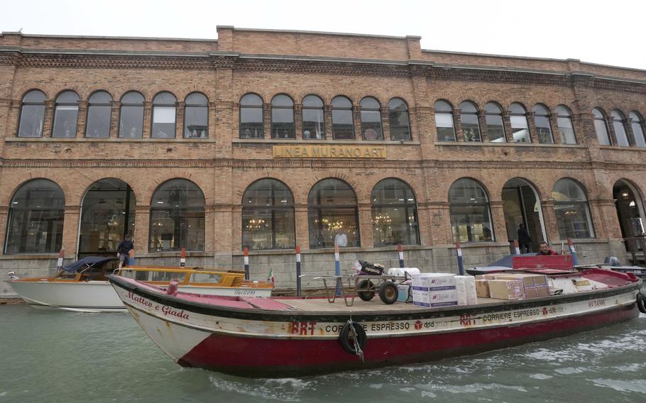 A boat sails past a historical artistic glass factory in Murano island, Venice, Italy, Thursday, Oct. 7, 2021.