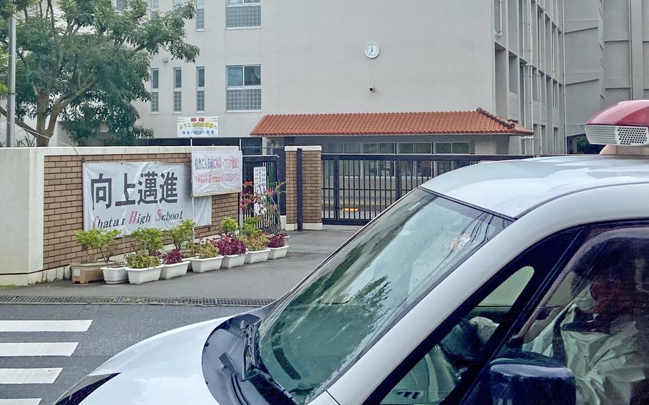 A policeman watches over Chatan High School in Chatan town, Okinawa, Friday, Feb. 4, 2022.  Schools and city offices were closed for the day because of a bomb threat. 