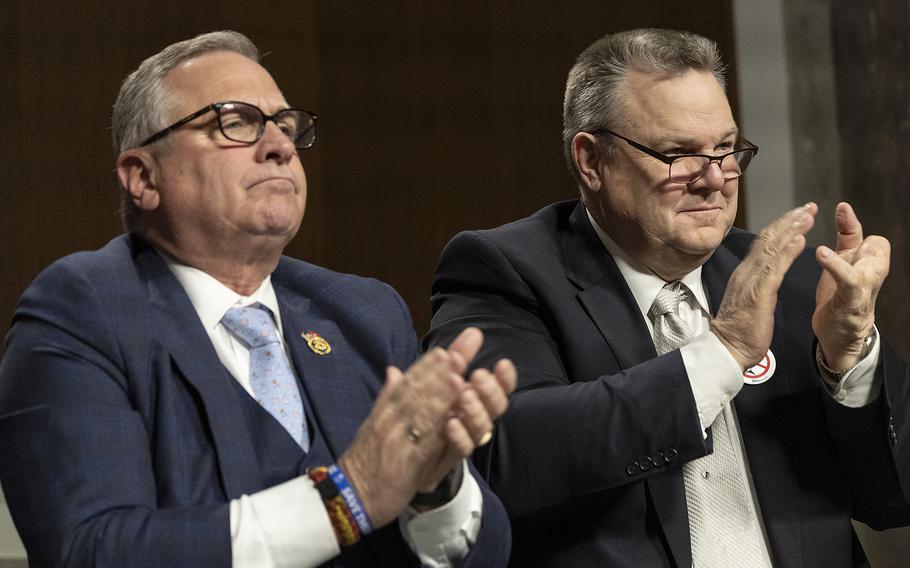 Rep. Mike Bost, R-Ill., chairman of House Veterans’ Affairs Committee, and Sen. Jon Tester, D-Mont., chairman of Senate Veterans’ Affairs Committee, applaud veterans in attendance March 6, 2024, at a joint committee hearing on Capitol Hill.