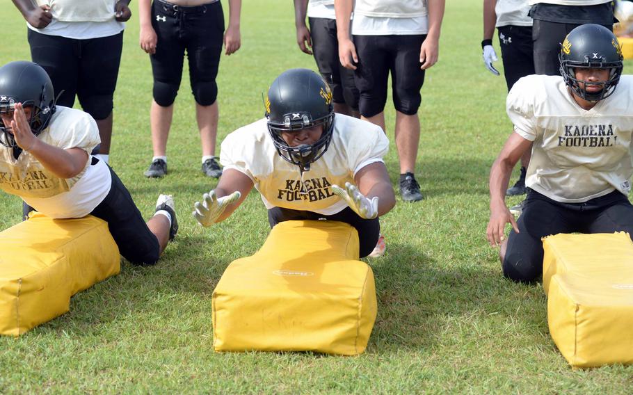 Kadena's Adam Santana, Richard Gantz and Braylon Stephens go through a dive tackle drill.