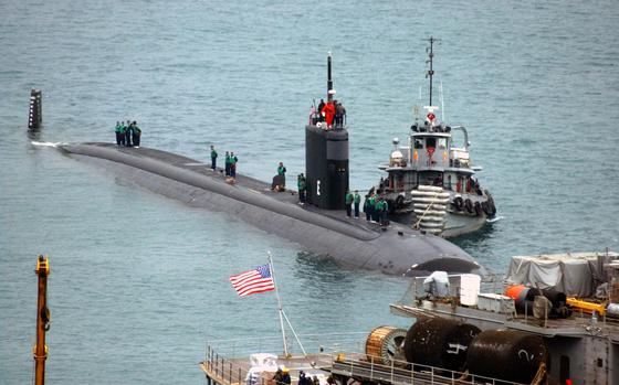 (1) 030221-N-0780F-020
(2) Souda Bay, Crete, Greece (Feb. 21, 2003) -- Nuclear-powered submarine USS San Juan (SSN 751) arrives for a port visit and prepares to be berthed outboard of submarine tender USS Emory S. Land (AS 39)
(3) San Juan is homeported in Groton, CT 
(4) U.S. Navy photo by Paul Farley