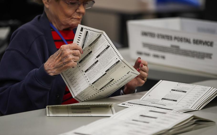 Election workers look over ballots for readability at the Maricopa County Tabulations and Election Center the day after the midterm elections on Nov. 9, 2022, in Phoenix. 